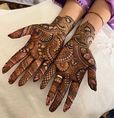 two hands with henna designs on them