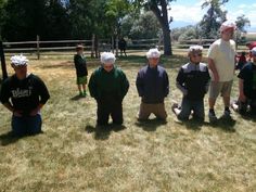 several people wearing paper hats standing in the grass