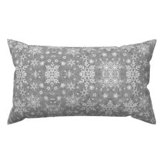 a white and grey pillow with snowflakes on the front, sitting against a white background