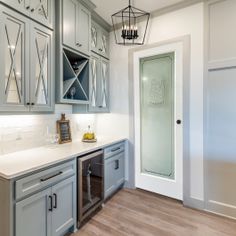 a kitchen with gray cabinets and white counter tops