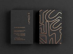 two business cards on top of each other with an abstract design in gold and black