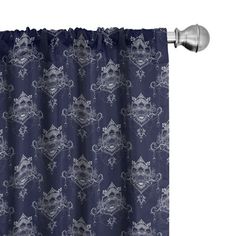 a blue and white shower curtain with an ornate design on it, hanging from a metal pole