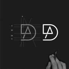 a person writing on a piece of paper with the letter d in white and black