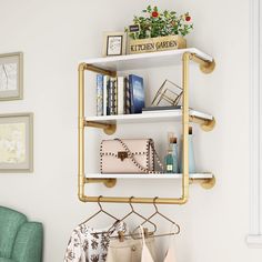 a white shelf with some purses and books on it next to a green chair