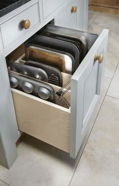 an open drawer in the middle of a kitchen