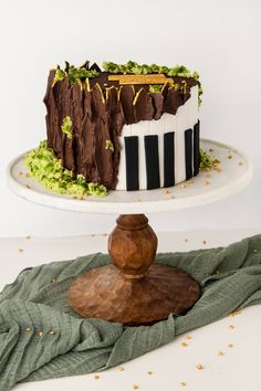 a cake that is sitting on top of a wooden stand and has piano keys painted on it