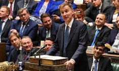 a man standing at a podium in front of a group of people with briefcases