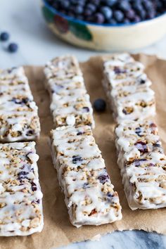 blueberry granola bars are lined up on parchment paper