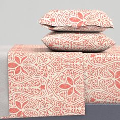 three pillows are stacked on top of each other in front of a gray background with red and white designs