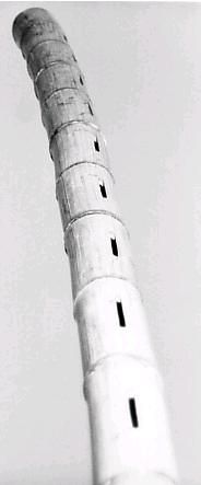 a tall white tower with black dots on it's side and the top part of it