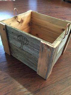 a wooden crate with the letter p on it sitting on top of a hard wood floor