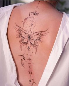 the back of a woman's neck with a butterfly tattoo on it and leaves