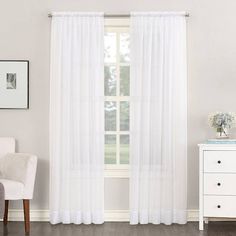 a living room with white furniture and curtains