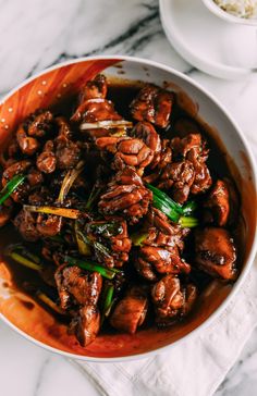 a bowl filled with meat and vegetables on top of a table