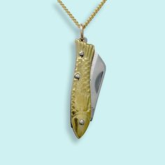 A tiny gold fish folding knife with a sharp blade on a gold curb chain. Metal: Stainless steel blade, 18kt gold-plated chain Size: 1" L knife Lobster Clasp Available in 16", 18", and 20" chain (18" Fits Most) Chain is made in the USA, Knife is made in China Word to the wise: This is a real knife and the blade is sharp. Don't wear it with the knife open. Keep it out of reach of children. Use caution when opening and closing it (if you've never opened a pocket knife, please take a minute to find a YouTube video to learn). Gold Fish Necklace, Gold Compass Necklace, Knife Necklace, Gold Curb Chain, Engagement Gifts For Her, State Necklace, Fish Knife, Fish Necklace, 40th Gifts