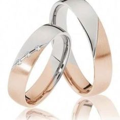 two white and rose gold wedding rings with diamond in the middle, set on top of each other