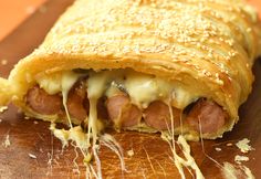 a close up of a piece of food on a cutting board with cheese and meat