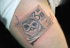 an owl tattoo on the right thigh with postage stamp in it's left arm