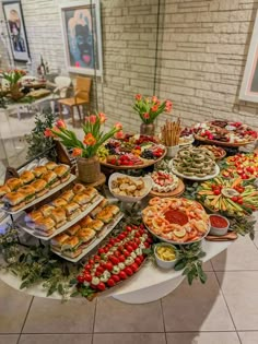 a buffet table filled with lots of different types of food on plates and trays