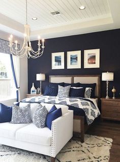 a bed room with a neatly made bed and a chandelier