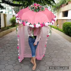 a woman standing under an umbrella with flowers on it