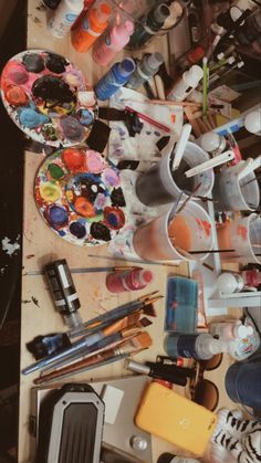 the table is full of art supplies and paints