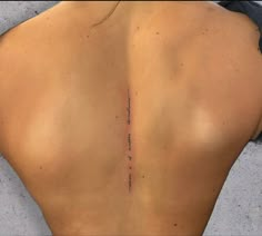 the back of a woman's lower back with writing on it and an arrow