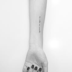 a black and white photo of a person's arm with a tattoo on it