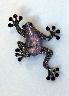 a purple frog brooch sitting on top of a white table