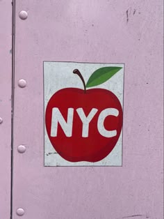 an apple sticker on the side of a pink door