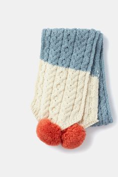 a blue and white knitted mitt with red pom - pom on it