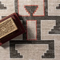 a small box sitting on top of a rug with an ornate design in the middle