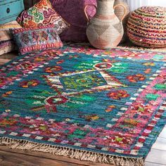 a colorful area rug is on the floor next to a vase and other decorative items