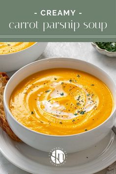 a bowl of creamy carrot parsnip soup on a white plate with bread