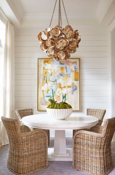 a dining room table with chairs and a painting on the wall