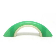 a green and white arch shaped object against a white background