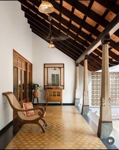 the inside of a house with an open floor plan and wooden ceiling beams, two chairs on either side of the room