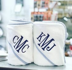 two white towels that are sitting on top of a table with monogrammed letters