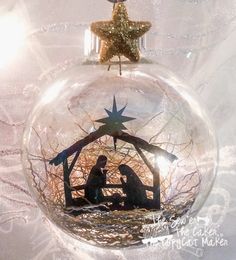 a glass ornament with a nativity scene in the shape of a star