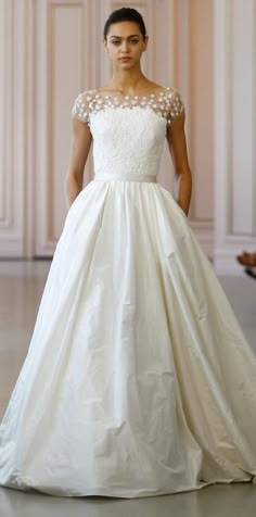 a woman in a wedding dress on the runway