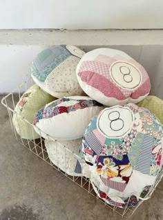 a basket filled with lots of pillows on top of a floor