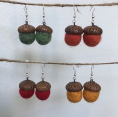 four different colored acorns hanging from a line