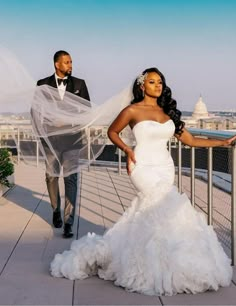 the bride and groom are walking down the bridge