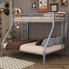 a metal bunk bed sitting in a bedroom next to a wall with pictures on it