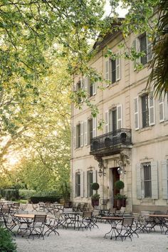 an old building with tables and chairs outside