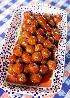 there is a plate full of meatballs on the table with blue and white checkered cloth