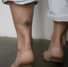 a woman's leg with a tattoo on it and an eye in the center