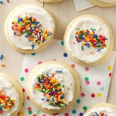 cookies with frosting and sprinkles on a table