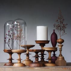 various vases with flowers and plants in them sitting on a wooden table next to each other