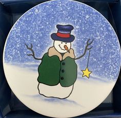 a plate with a snowman holding a star in it's hand and wearing a hat